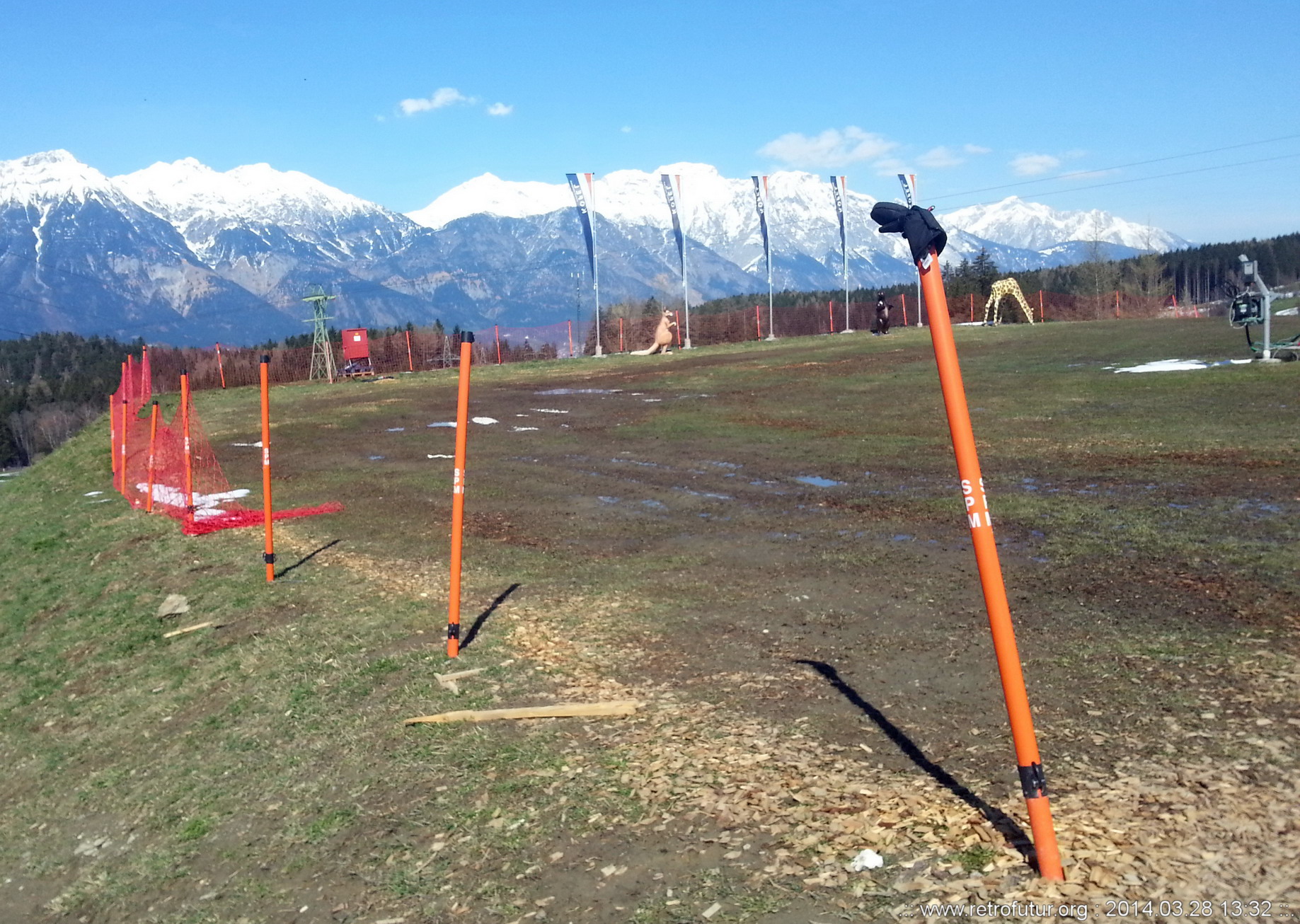 Skitour vs. Industrieski am Beispiel der Querung vom Glungezer Gipfel über Zirbenweg bis hinab nach Igls : Passt nicht. Erfordernisse des Sicherns und Versicherns. Im Hintergrund Fahnen, dazwischen Känguru, Braunbär und Giraffe (mit gesenktem Kopf ,Kunststoff).